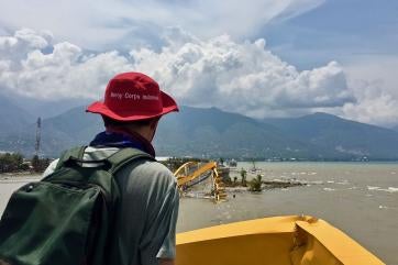 Prosper global employee surveying damage to a bridge, which is underwater