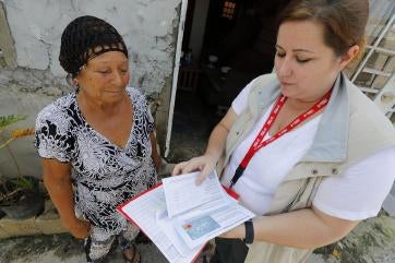 Prosper global employee working with woman aid recipient. 