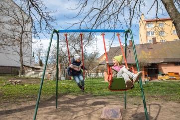 Children playing on a swing set. 