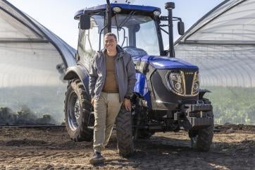Ukrainian man stands in front of tractor.