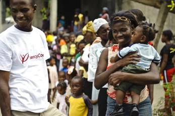 Man in prosper global shirt and crowd of families with children