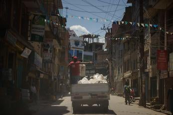 A truck with prosper global team members navigates a city street in nepal