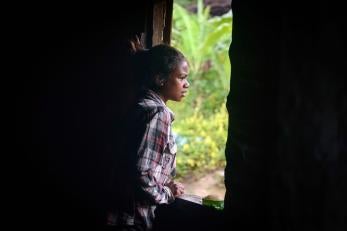 A girl looks out the window in timor-leste