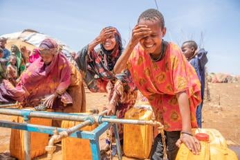 Children take a drink and wash their faces at a prosper global water point in the displacement camp near baidoa, somalia.