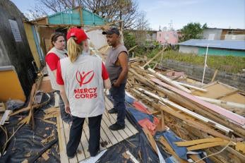 Prosper global employees speaking with a man impacted by hurricane maria