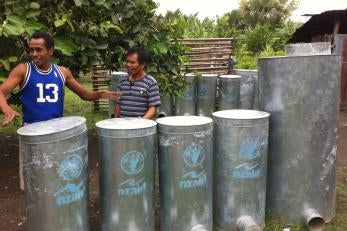 Mario de Jesus (at left, in blue shirt) and other local blacksmiths are benefitting from Prosper Global's SECURE program by building silos for sale to neighboring farmers. Photo: Wahyu Nugroho/Prosper Global
