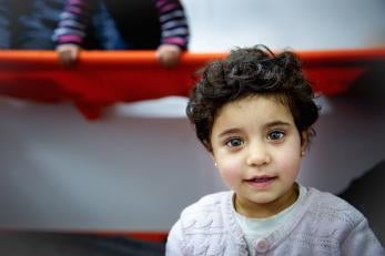 A very young girl standing in a warming tent
