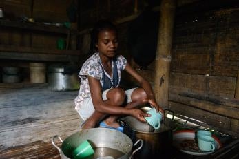 A girl cleaning dishes in timor-leste