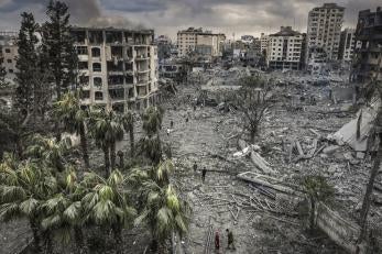 Residents walk through the rubble of the Al-Remal neighborhood in Gaza City after it was destroyed by air raids. © Eyad Baba for Prosper Global