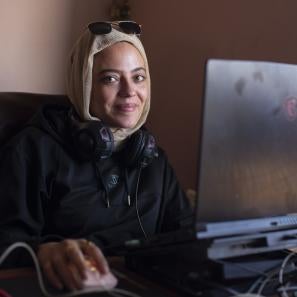 Gaza sky geeks participants sits at her desk in front of computer.