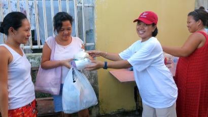 Dewi Hanifah distributed food and hygiene supplies to women who have been waiting days for help. Photo: Prosper Global