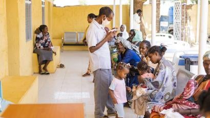 Patients wait outside the Prosper Global-supported health clinic in Um Rakuba.