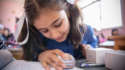 At an inclusive school in Zarqa, students with visual impairments like Noor use a magnifier to help with learning.