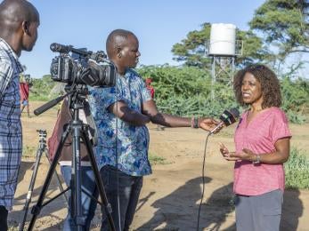 Prosper Global CEO being interviewed by Kenyan press in an outdoor setting.